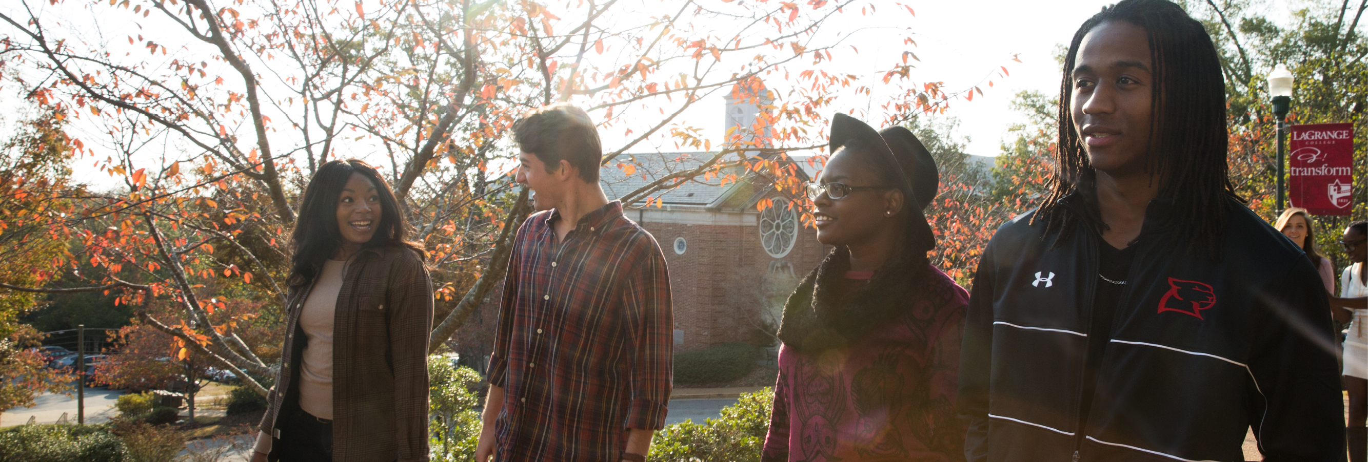 Students walk along a cobblestone path with the College chapel in the background