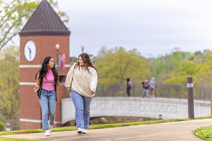 Two female students walk in front of the Gulley Gateway bridge