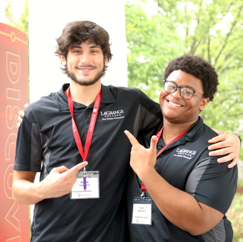 Two college students smile at the camera