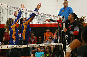 Volleyball player jumping in the air hitting the ball