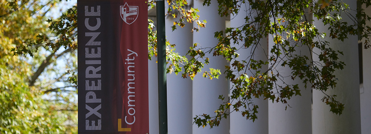 a campus banner beside white pillars
