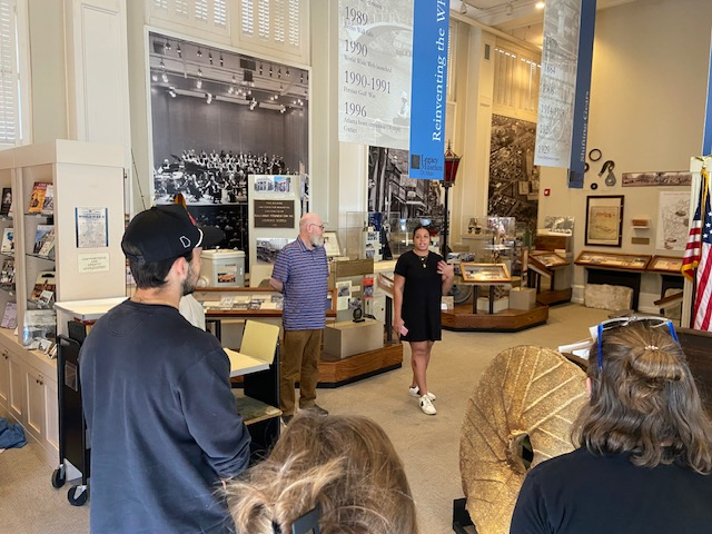 A group of history students listen to a lecture while on a field trip