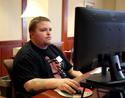 A male student works at a computer