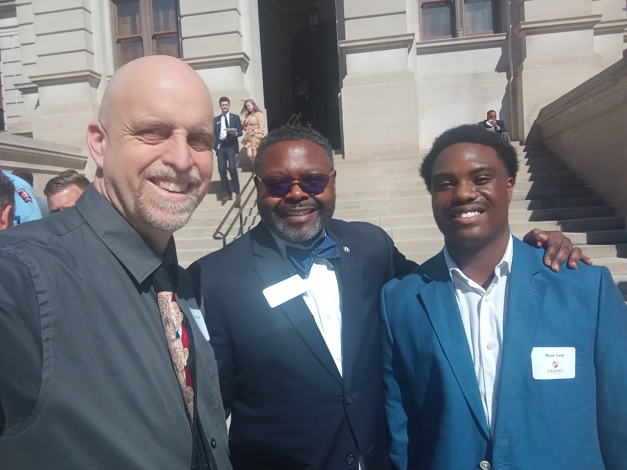 A student poses with two adult mentors