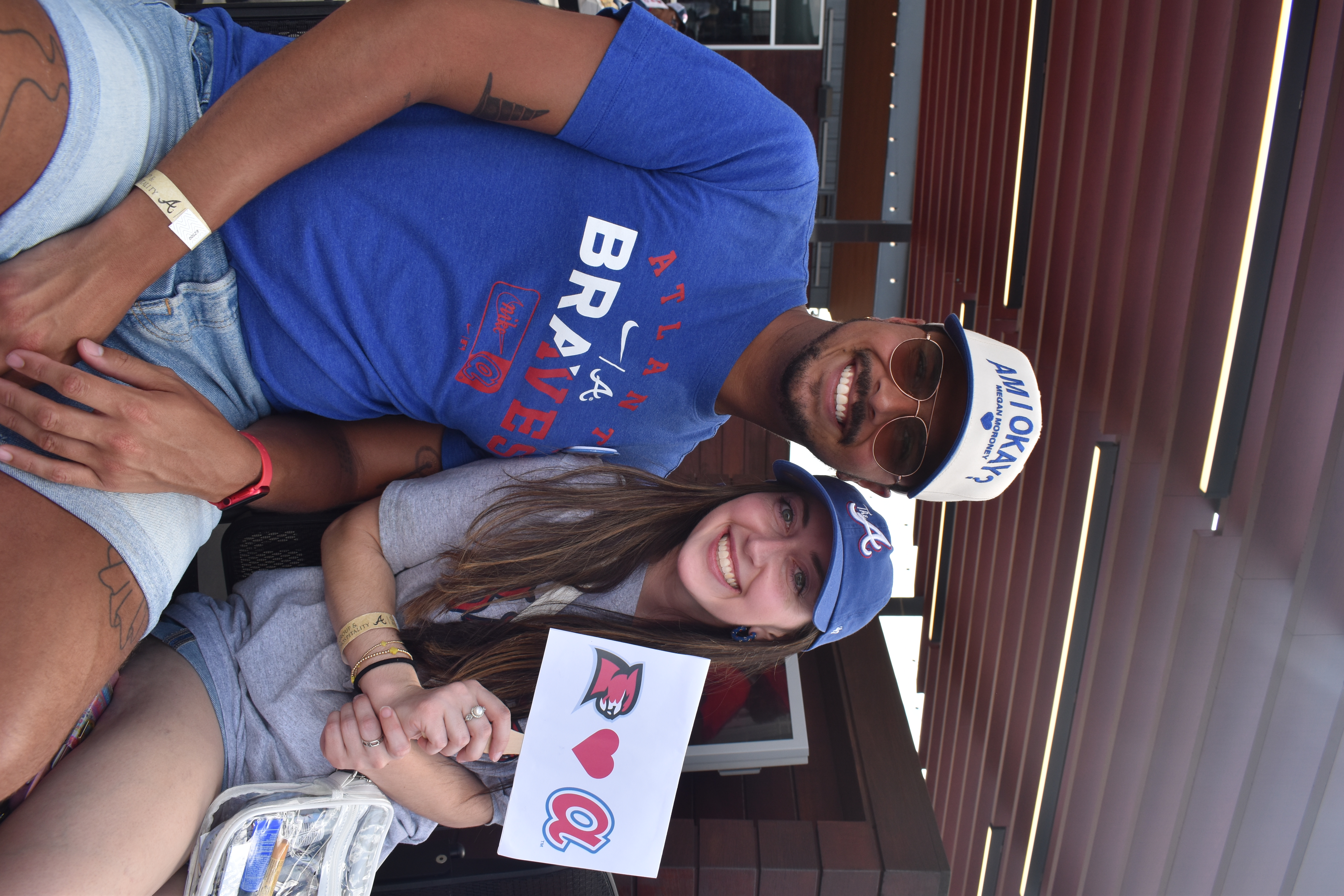 A boy and girl smiling at the camera sporting Braves gear